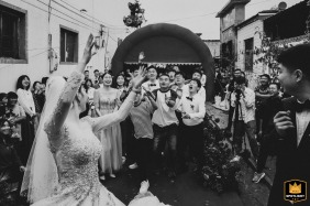 Bridal party members and friends eagerly reach and jump for the tossed bouquet at a wedding reception in Kaifeng, China.
